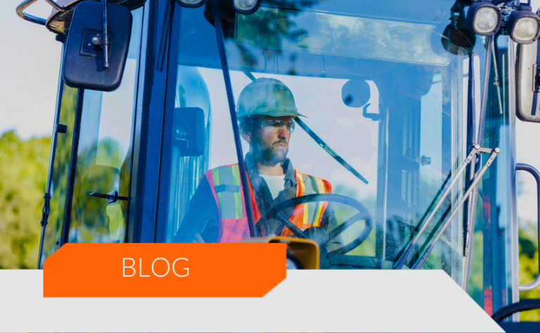 "Trabalhador da construção civil, usando capacete e colete refletivo, operando uma máquina pesada.